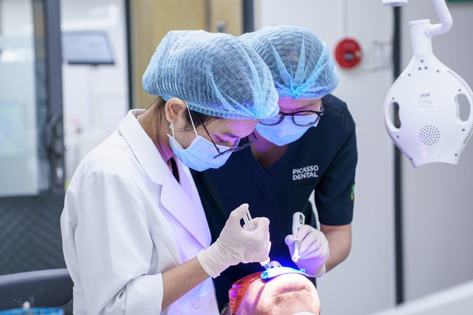 Dentist applying teeth whitening gel at Picasso Dental Clinic - Da Nang Flagship